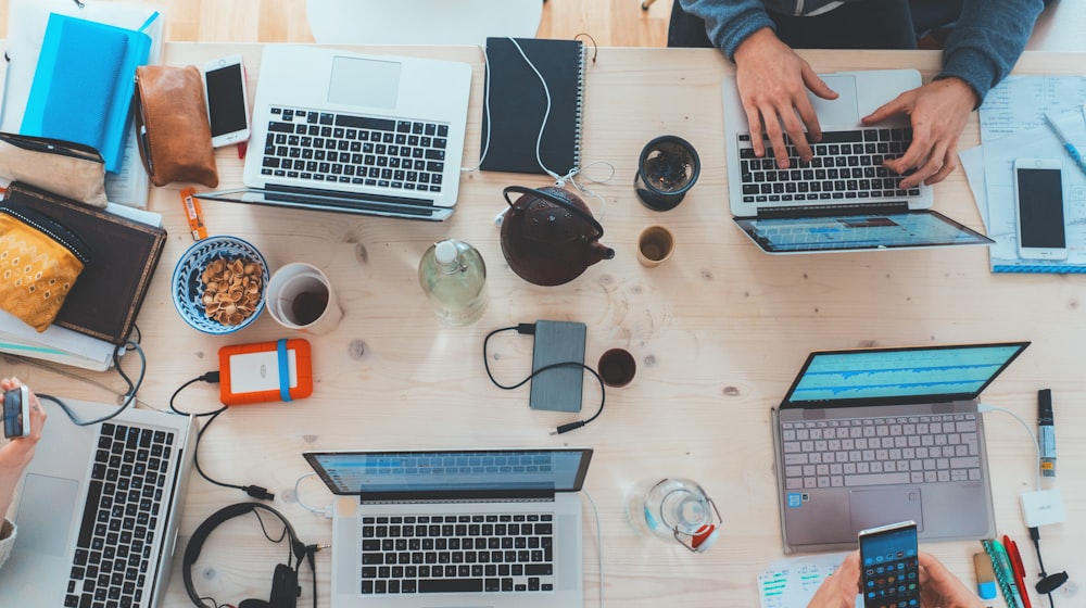 Overhead view of a startup team's laptops and devices on a shared desk